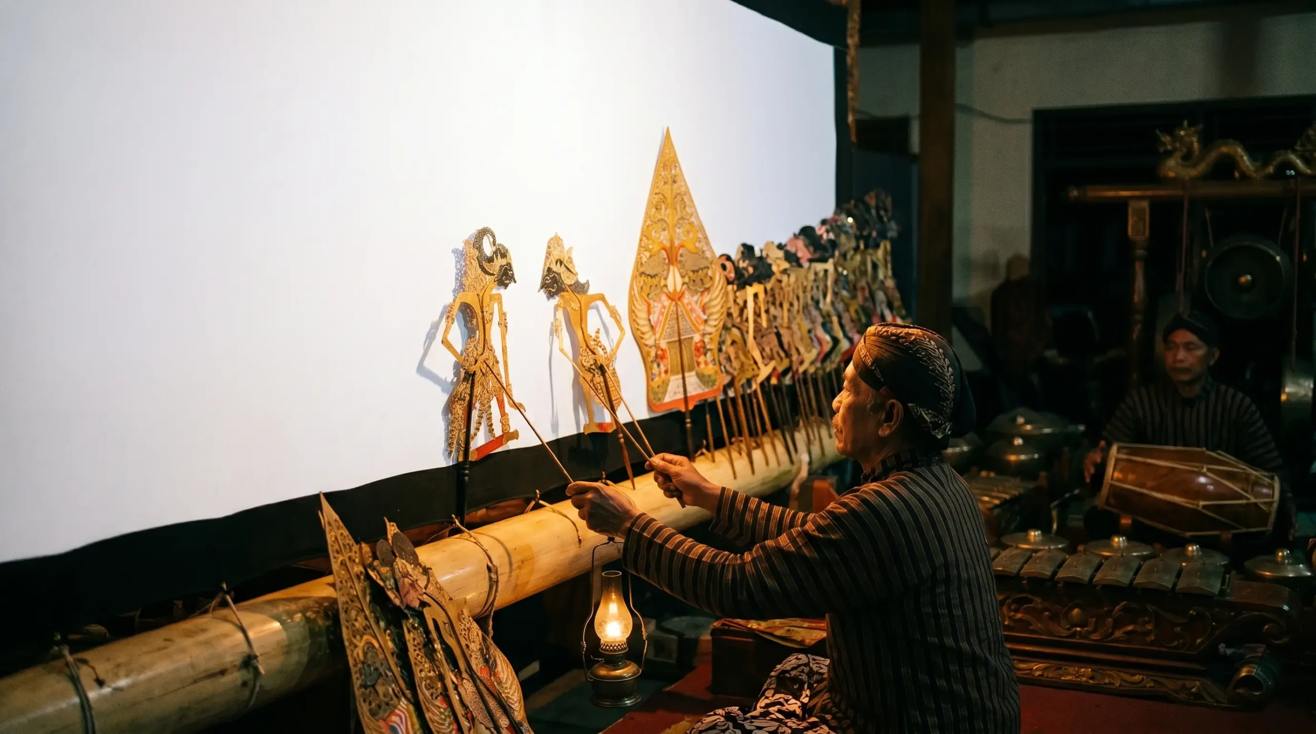 filosofi wayang Jawa dengan kelir blencong dan bayangan tokoh wayang
